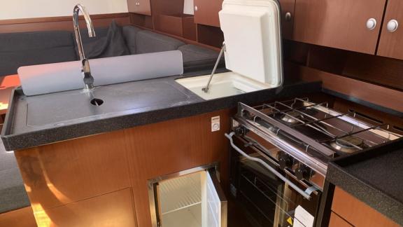 The kitchen area of the Deneb sailing yacht features a sink, stove, and refrigerator.