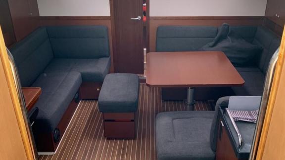 The salon of the Deneb sailing yacht features a spacious seating area and a table.