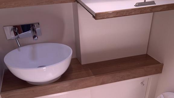 The bathroom of the Okhotnik yacht features a stylish sink and wooden details.