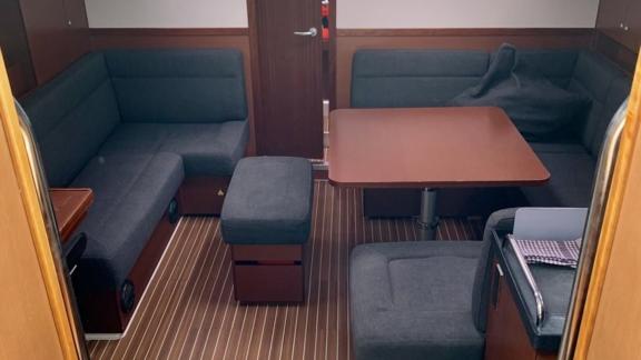 The salon of the Okhotnik yacht features a comfortable seating area with dark-colored furniture.