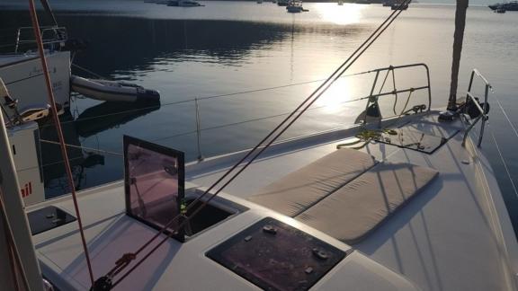 The foredeck of the Procyon sailing yacht, bathed in morning light in a calm marina.