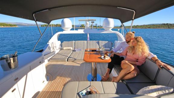 A couple enjoying the sea on the deck of the Hope I yacht, savoring a peaceful moment.