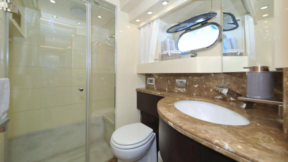 Modern bathroom on Hope I yacht with marble countertop and shower cabin.