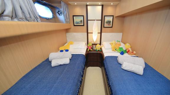 Twin bedroom for kids on Hope I yacht, decorated with cute toys.