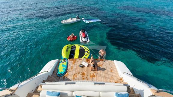 Personen bereiten Wassersportgeräte auf dem Deck der Illya F Yacht im klaren Wasser vor.