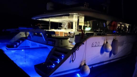 The Lagoon 620 Catamaran glows at night with impressive underwater lighting, illuminating the waters of Bodrum.