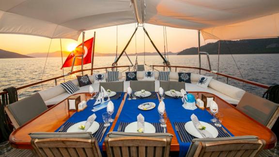 Enjoy a luxurious dinner on the deck of the Gulet Santa Maria at sunset on the open sea.