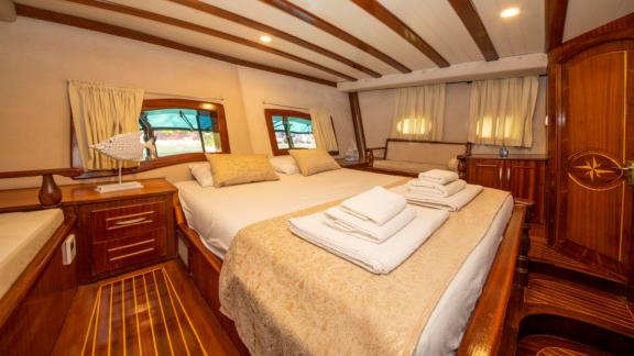 Relax in the luxurious cabin of the Gulet Santa Maria with elegant decor and a cozy bed.