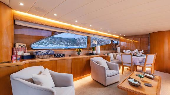 The salon of Dream motor yacht in Athens features large windows, lounge seating and a dining table.