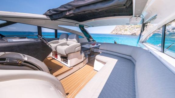 The deck of yacht Make My Day features a spacious seating area with a view of the sea.