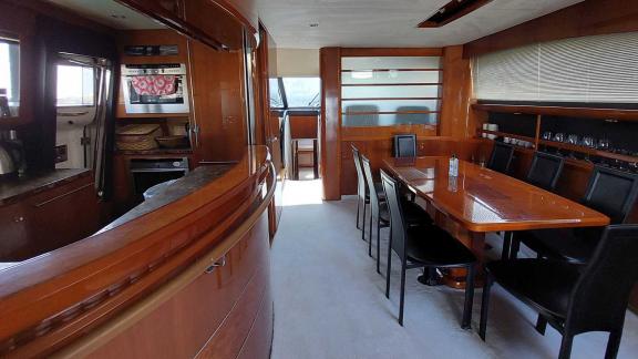 The dining area and kitchen of the yacht Cielo are equipped with a large table and modern kitchen appliances.