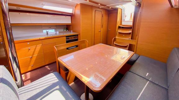 Salon of the sailing yacht Sam's Wind featuring a spacious seating area and dining table.