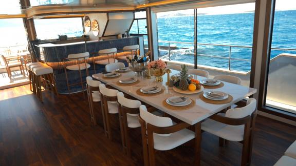 Im Inneren der Brise-Yacht befindet sich ein stilvoller Esstisch mit Meerblick.