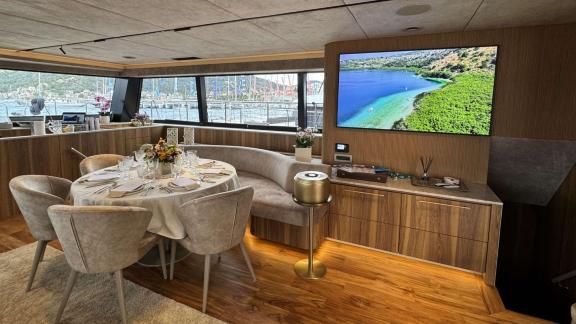 Der Salon von Honeymoon bietet einen runden Tisch und einen großen Fernseher.