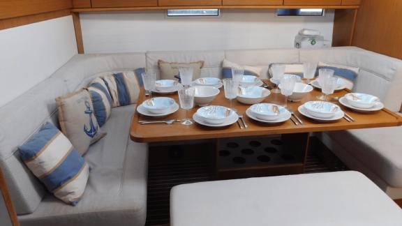 Der Essbereich im Salon der Yacht Lina besticht durch maritimes Dekor und einen stilvoll gedeckten Tisch.