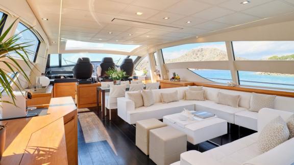 The interior of the For Ever yacht features chic seating and large windows overlooking the sea.