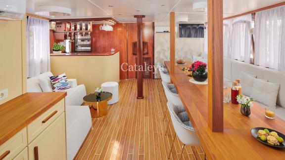 Bright and cosy saloon with bar, seating and decorative elements on the Gulet Cataleya.