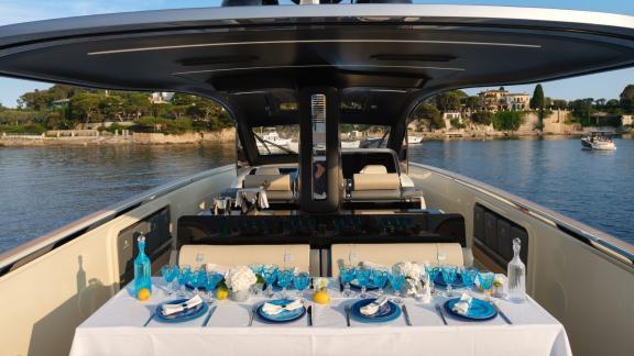 Among Monaco yacht rental options Baccarat motor yacht shows shaded deck with elegant dining table setup.