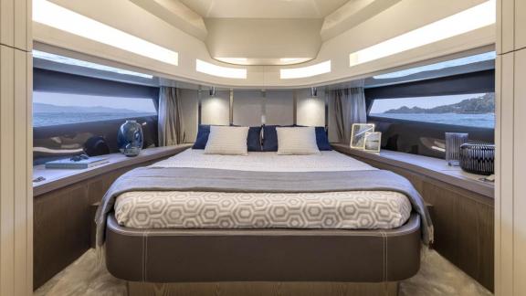 Among Monaco yacht rental options Baccarat motor yacht shows cabin with large bed and wide sea view windows.