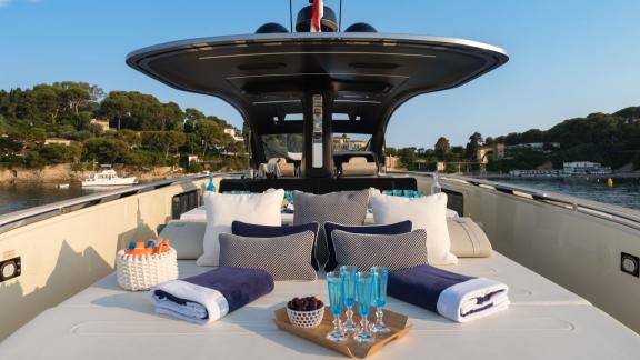 Among Monaco yacht rental options Baccarat motor yacht shows front deck with cushions and service setup.