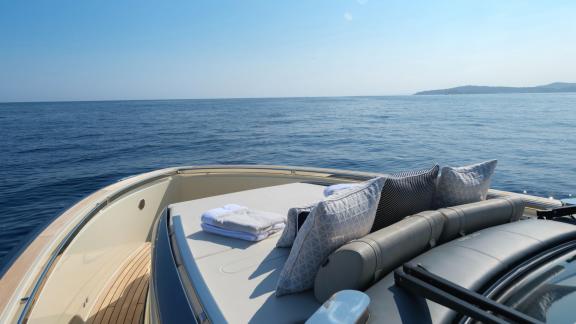 Among Monaco yacht rental options Baccarat motor yacht shows front deck with cushions and open sea view.