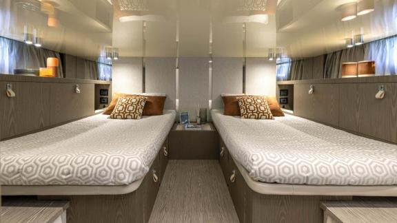 Among Monaco yacht rental options Baccarat motor yacht shows cabin with two separate beds for comfortable stay.