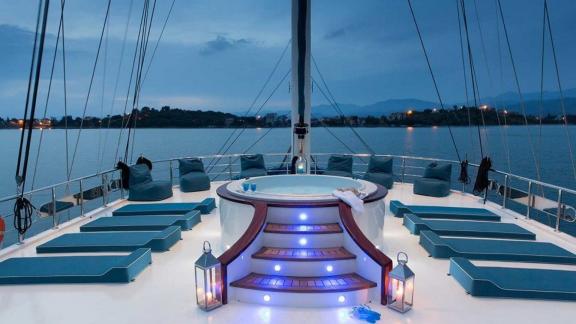 Jacuzzi and loungers on the deck of the gulet Queen Atlantis for a luxury getaway.