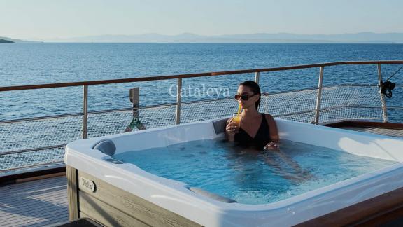 Woman enjoying a drink in the whirlpool on the deck of the 9-cabin gulet Cataleya, off the coast of Croatia.