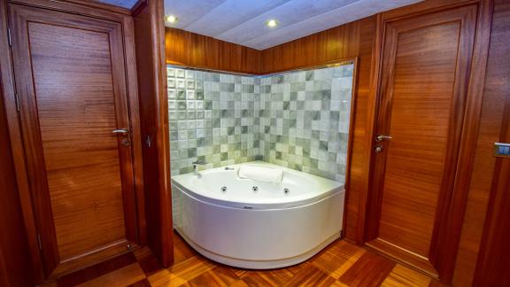 A luxurious corner bathtub in a wood-panelled cabin of the gulet 'Ugur'.