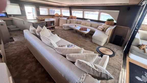 Eleganter Wohnbereich mit beigen Sofas und großen Fenstern, die einen Blick auf das Meer bieten.