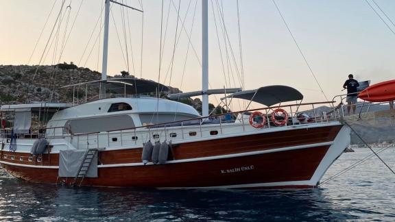 Traditionelle Holzgulet vor malerischer Küste, ideal für luxuriöse Yachtcharter.