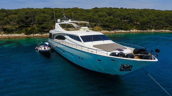 Motoryacht Katariina ankert vor einer grünen Küste in Kroatien mit klarem, blauem Wasser und ruhiger Umgebung.