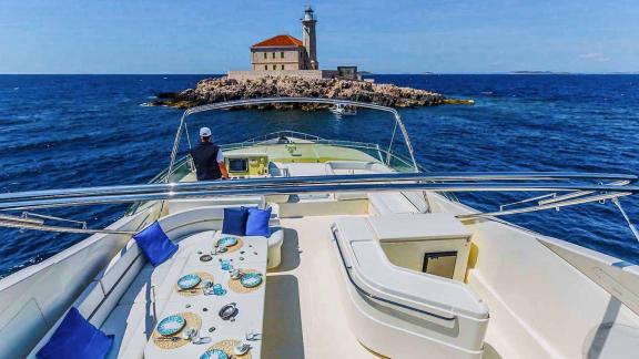 Mittagessen auf der Motoryacht Katariina mit Blick auf einen historischen Leuchtturm in Kroatien.