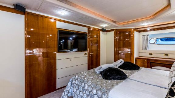 Komfortables Schlafzimmer mit Flachbild-TV und eleganter Holzausstattung auf der Motoryacht Katariina in Kroatien.