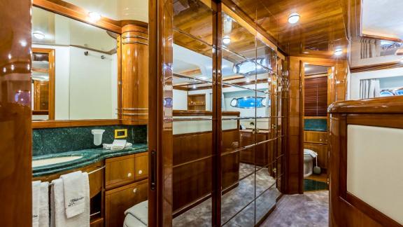 Bathroom with fine wood decor and green marble countertop on the motor yacht Katariina in Croatia.