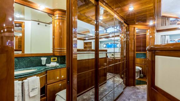 Badezimmer mit edlem Holzdekor und grünem Marmortisch auf der Motoryacht Katariina in Kroatien.