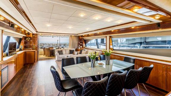 Stylish dining area and cozy living room on the motor yacht Katariina with panoramic windows in Croatia.