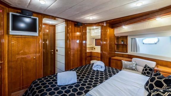 Elegantes Gästezimmer mit Flachbild-TV und stilvollem Holzdekor auf der Motoryacht Katariina in Kroatien.