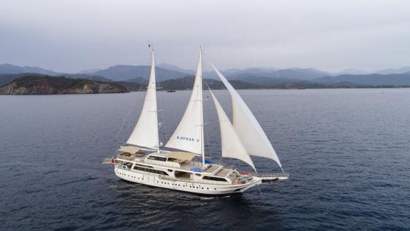 The elegant Gulet Kayhan 11 sailing off the coast of Fethiye, surrounded by mountains.