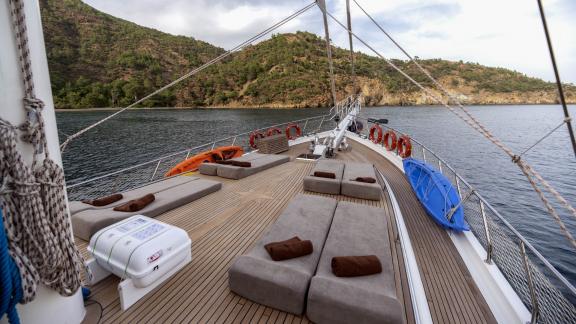 The deck of the Gulet Kayhan 3 offers comfortable sun loungers with a view of the picturesque coastline.