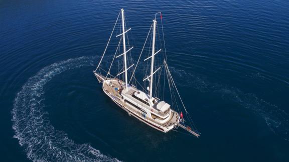 Traditional Turkish sailing boat with five cabins, cruising in the deep blue sea of Fethiye.