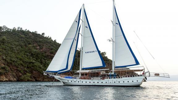 The gulet Kayhan 5 sails along a picturesque coastline in Fethiye, Turkey.