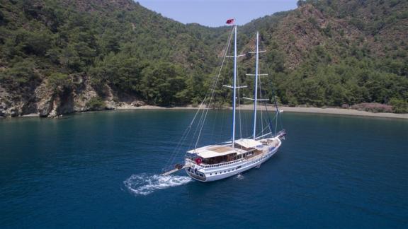 Die Yacht Kayhan 9 segelt in einer malerischen Bucht in Fethiye, ideal für einen ruhigen Urlaub.