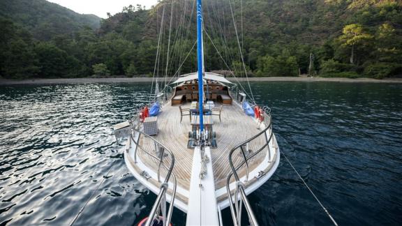 The foredeck of a luxurious yacht anchored in a secluded bay in Fethiye.