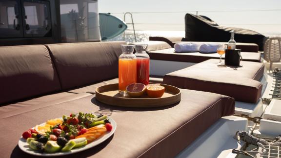 Sun deck with fresh juices and a fruit platter on the King of Diamonds, perfect for unwinding.