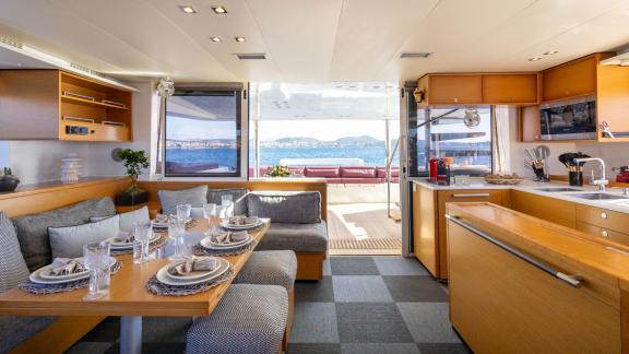 Stylishly set dining table and modern kitchen inside the King of Diamonds, with a view of the sea.