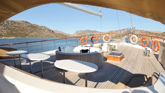Offenes Deck mit Sitzgelegenheiten und Whirlpool.