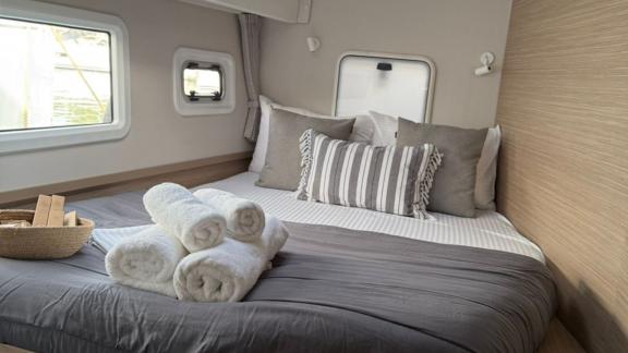 Bellatrix bareboat catamaran in Athens features cabin with large bed and natural light windows.