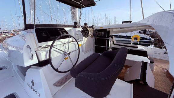 Among Athens bareboat catamaran charter options Bellatrix shows helm station and comfortable cockpit seating.