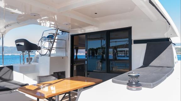 In Kastela bareboat catamaran charter Find Us with aft seating, table and sea view ideal for relaxing cruise.